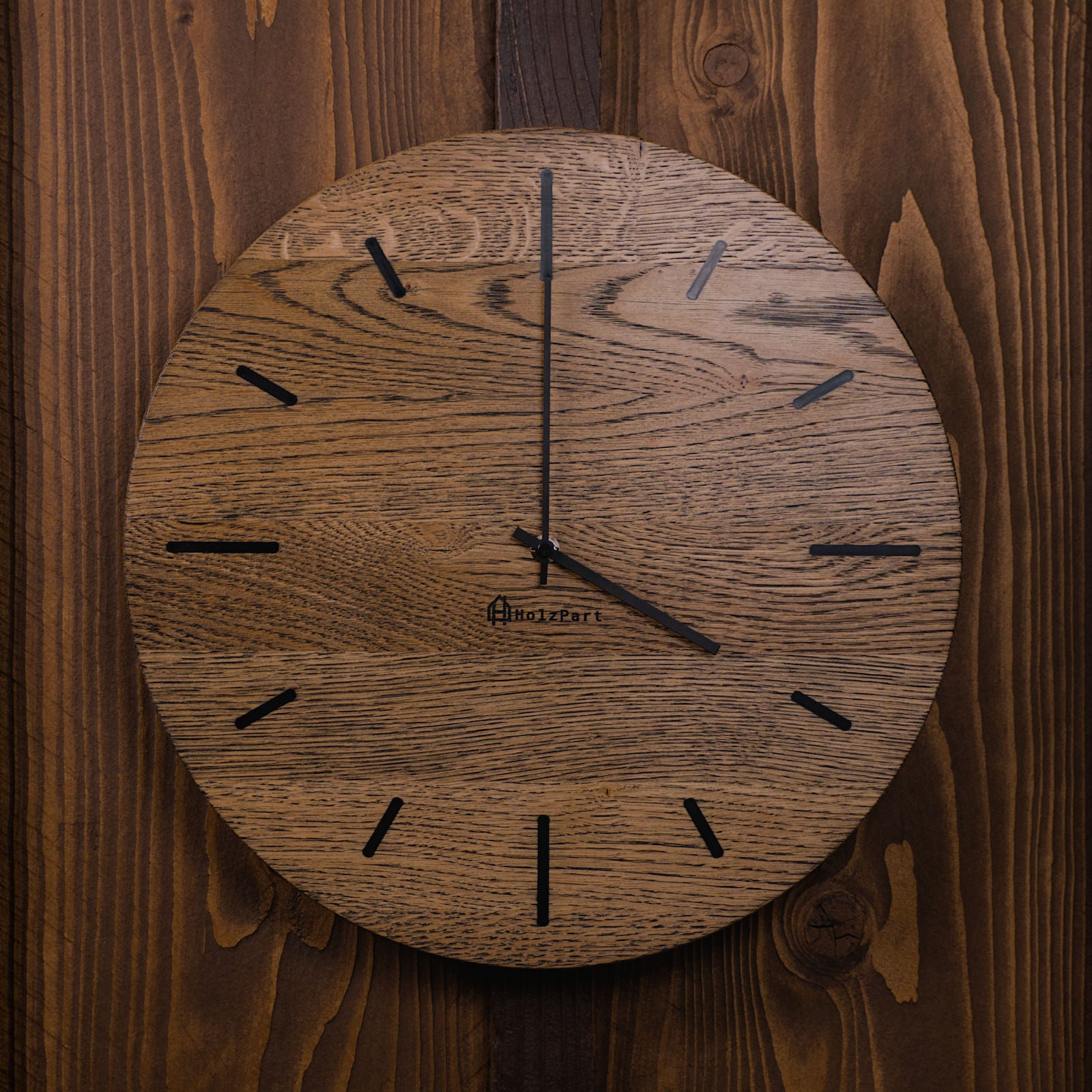 Runde Wanduhr aus colour geölter Eiche mit schwarzen Stundenstrichen – Frontalansicht, handgefertigt im Solothurner Unterleberberg von HolzPart.