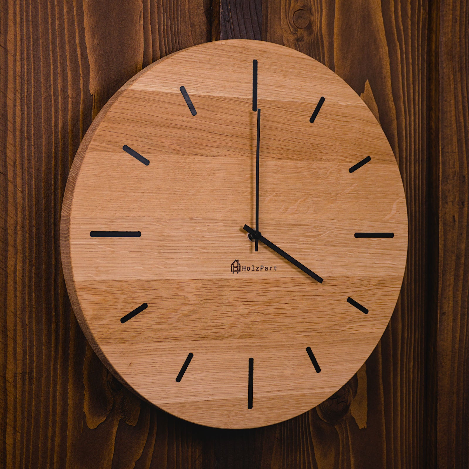 Handgefertigte Wanduhr aus geölter Eiche im Rohholzeffekt mit schwarzen Stundenmarkierungen – Seitenansicht der runden Uhr von HolzPart Schweiz.