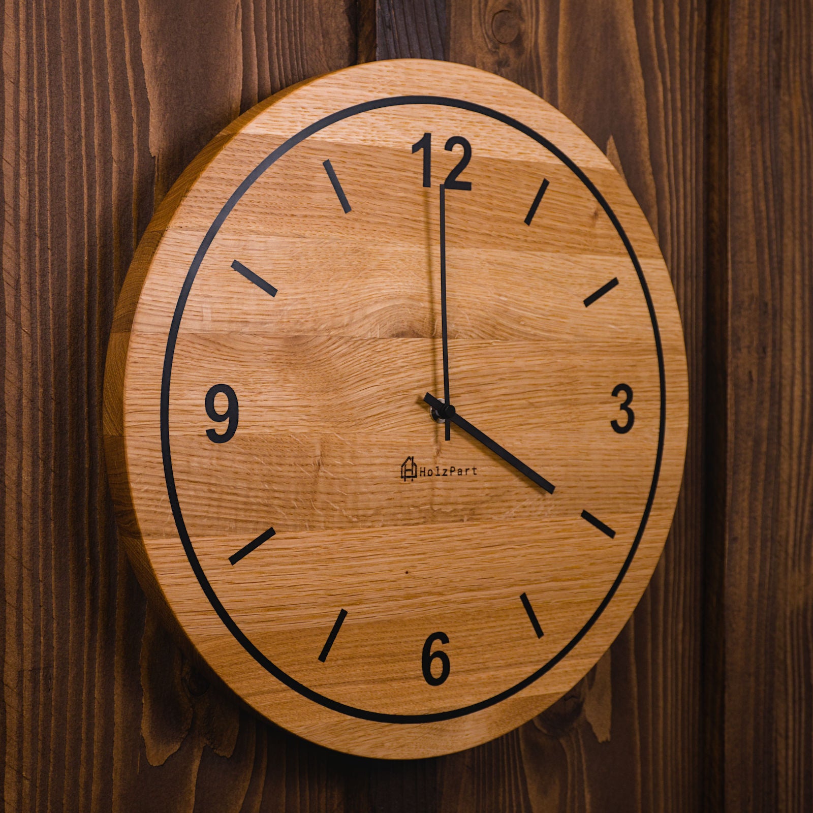 Handgefertigte runde Wanduhr mit Ziffern und Kreis-Design aus klassisch geölter Eiche – Seitenansicht der Uhr von HolzPart Schweiz.