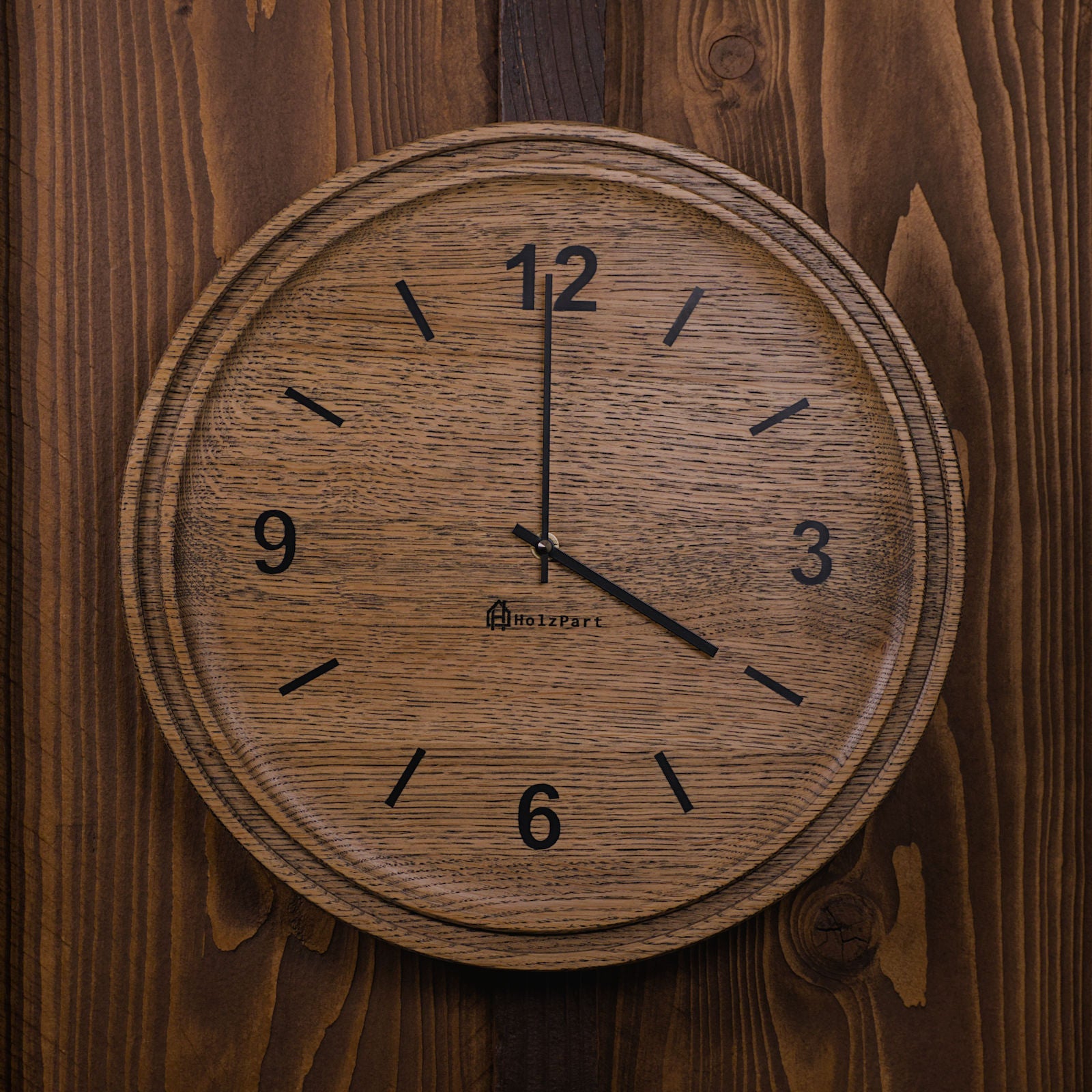 Runde Wanduhr mit Ziffern und doppeltem Rand aus colour geölter Eiche – Frontalansicht, handgefertigt im Solothurner Unterleberberg von HolzPart.