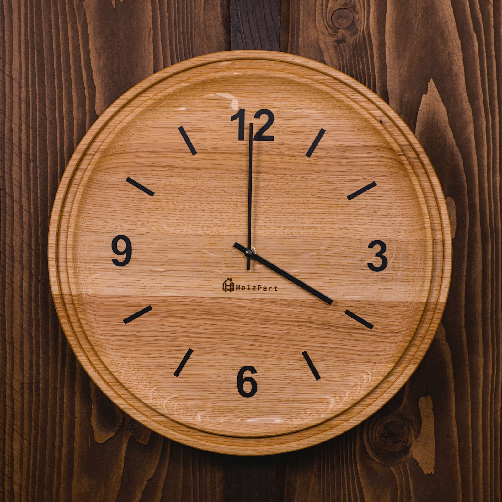 Runde Wanduhr mit Ziffern und doppeltem Rand aus klassisch geölter Eiche – Frontalansicht, handgefertigt im Solothurner Unterleberberg von HolzPart.