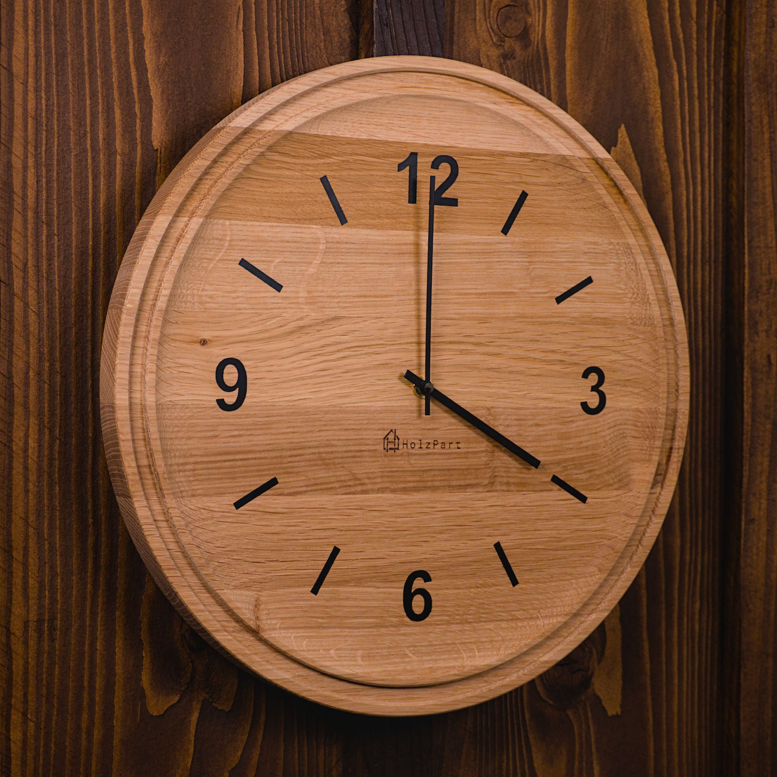 Handgefertigte runde Wanduhr mit Ziffern und doppeltem Rand im Rohholzeffekt – Seitenansicht der Uhr von HolzPart Schweiz.