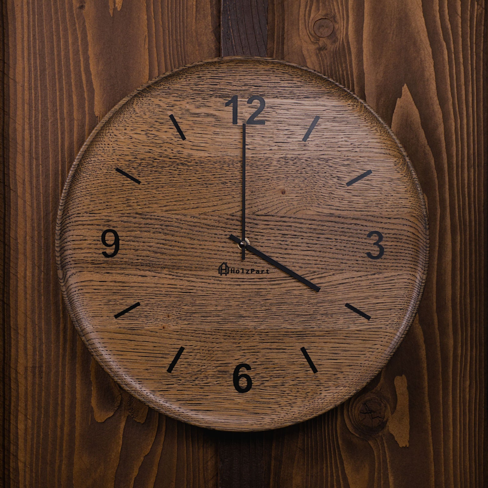 Runde Wanduhr mit Ziffern und flacher Schalenform aus colour geölter Eiche – Frontalansicht, handgefertigt im Solothurner Unterleberberg von HolzPart.