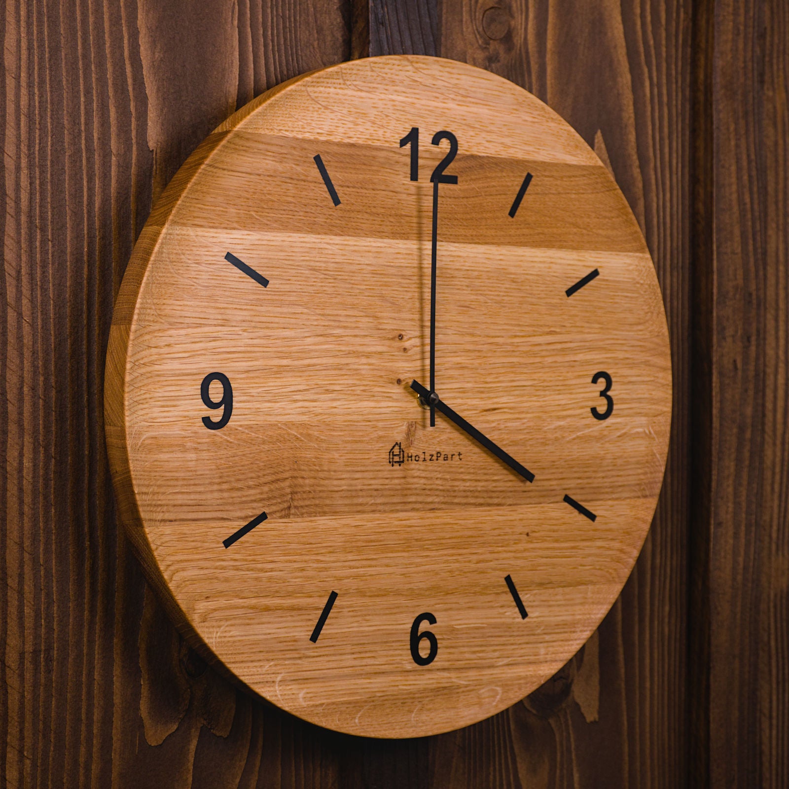 Handgefertigte runde Wanduhr mit Ziffern und flacher Schalenform aus klassisch geölter Eiche – Seitenansicht der Uhr von HolzPart Schweiz.