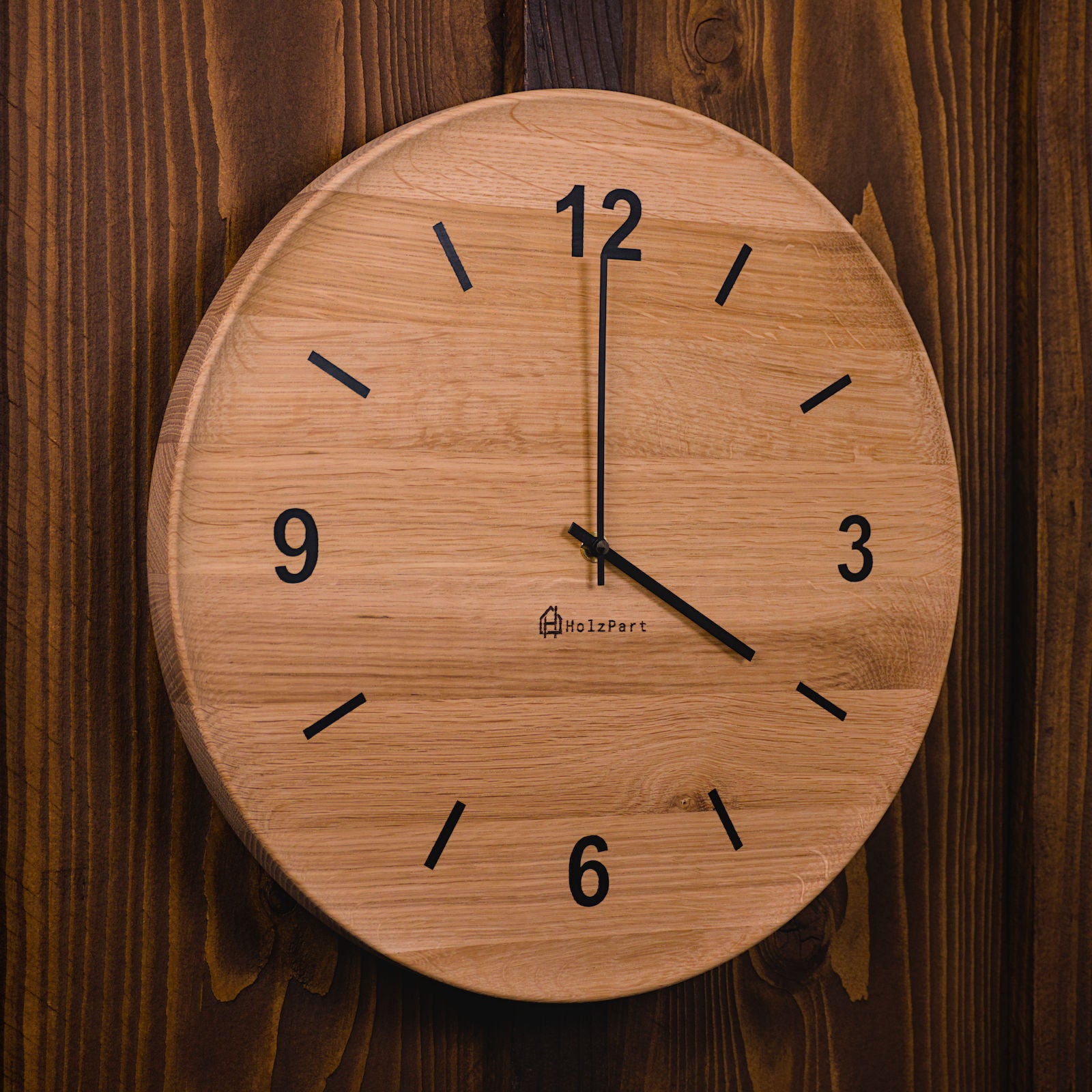 Handgefertigte runde Wanduhr mit Ziffern und flacher Schalenform im Rohholzeffekt – Seitenansicht der Uhr von HolzPart Schweiz.