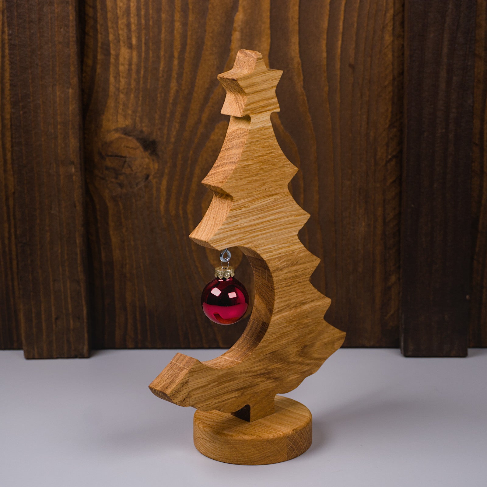 Holzweihnachtsbaum aus geöltem Eichenholz, rechte Seitenansicht mit roter Kugel.