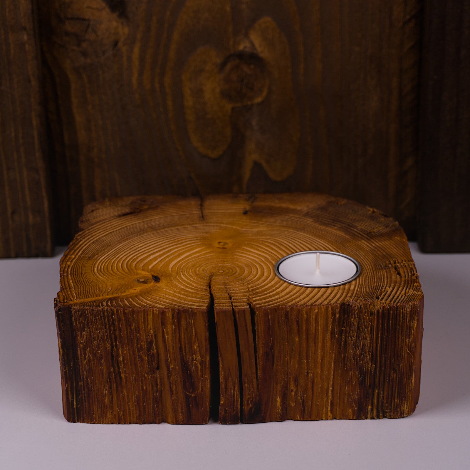 Kerzenständer aus Altholz in Frontalansicht mit Teelicht und markanten Rissen.