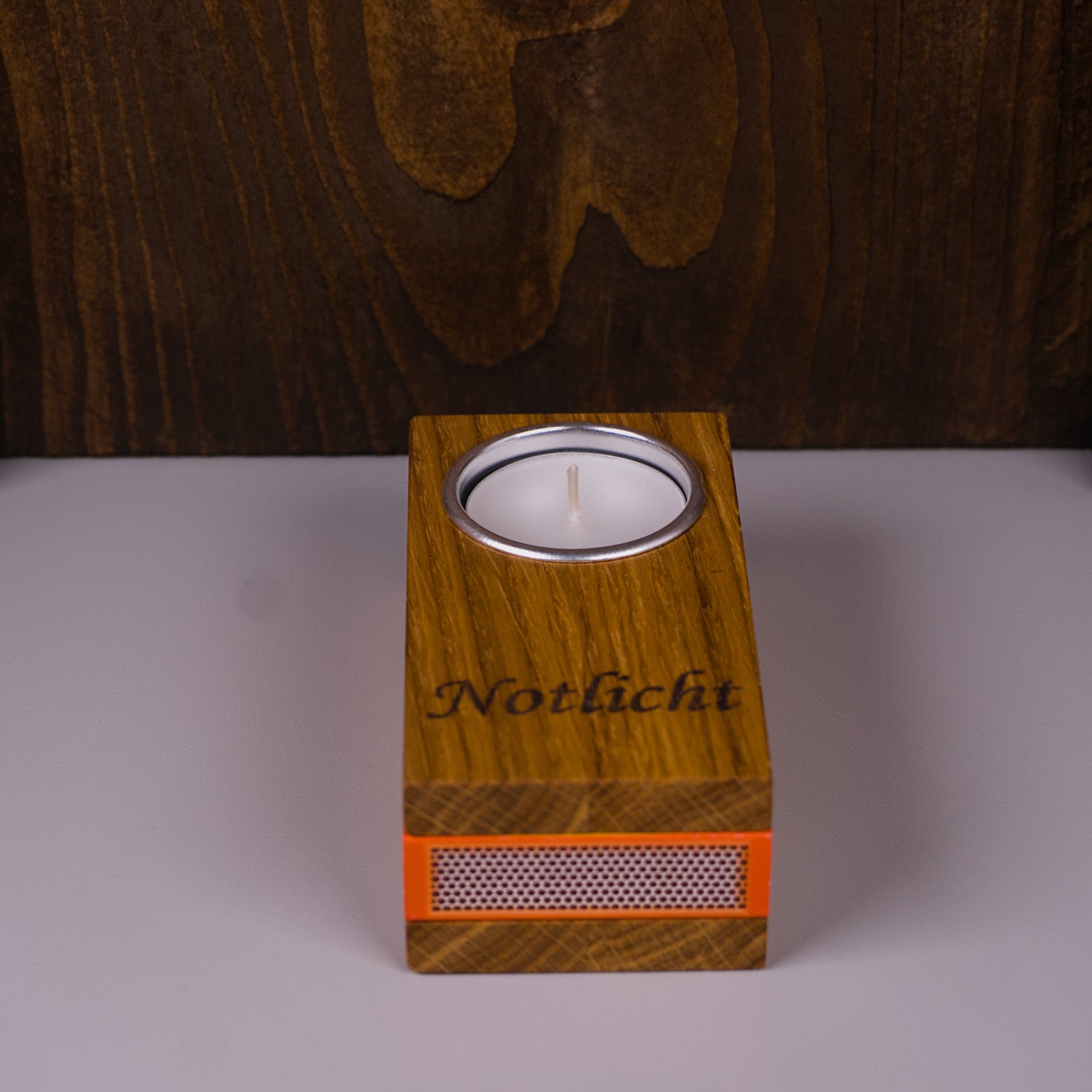Notlicht aus Eichenholz, Frontalansicht, Teelichthalter und Streichholzfach sichtbar.