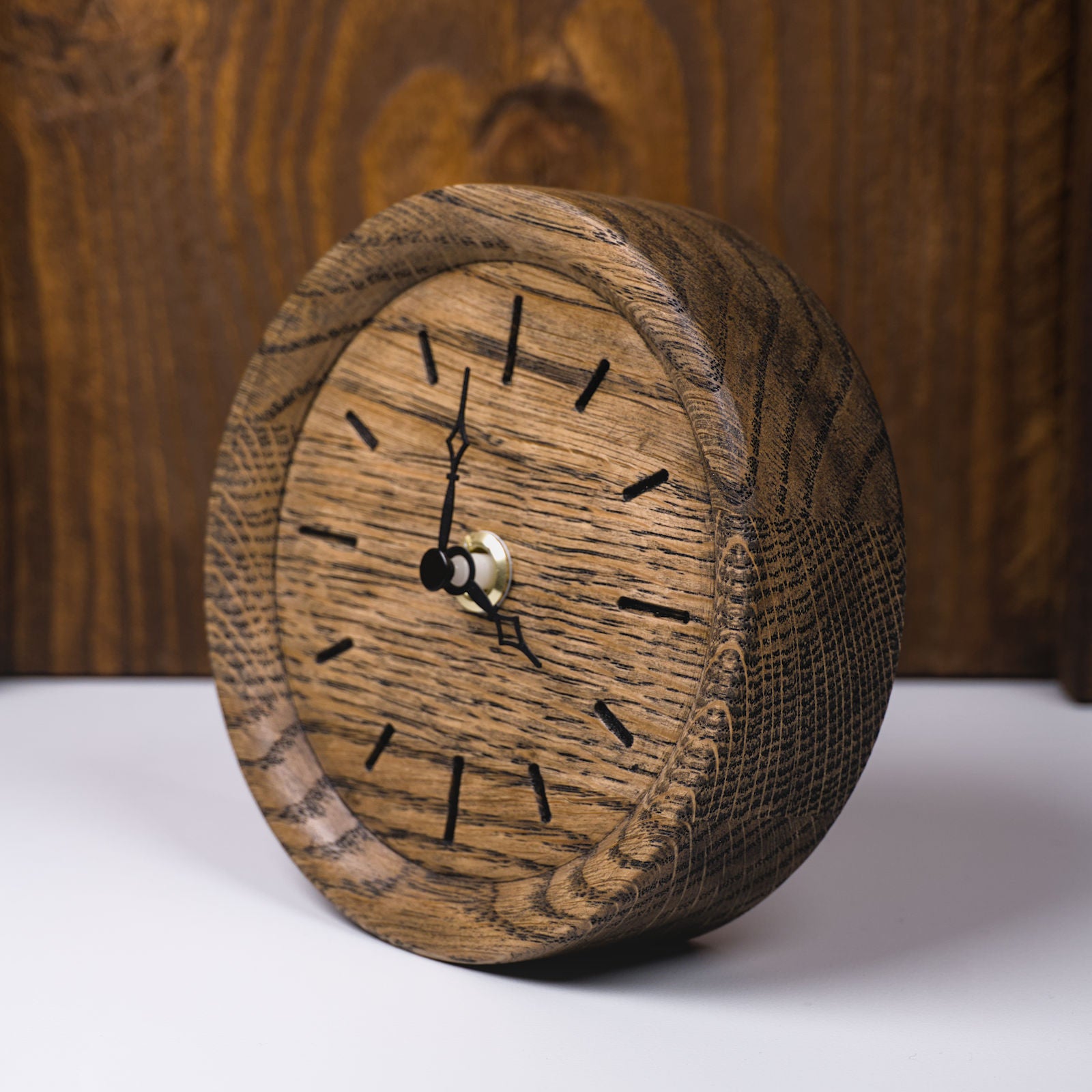 Runde Standuhr aus colour geölter Eiche mit eingefrästen Stundenmarkierungen – linke Frontseitenansicht, handgefertigt im Solothurner Unterleberberg von HolzPart.