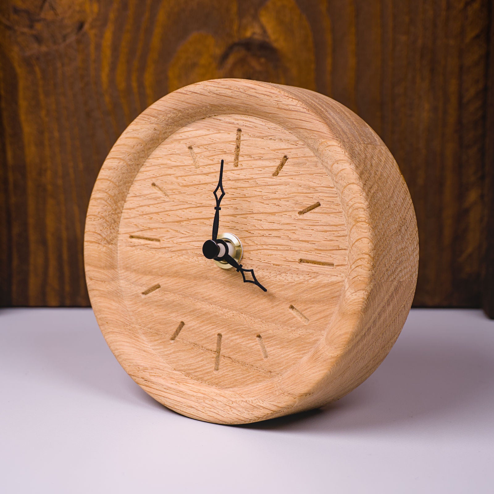 Runde Standuhr im Rohholzeffekt mit eingefrästen Stundenmarkierungen – linke Frontseitenansicht, handgefertigt im Solothurner Unterleberberg von HolzPart.