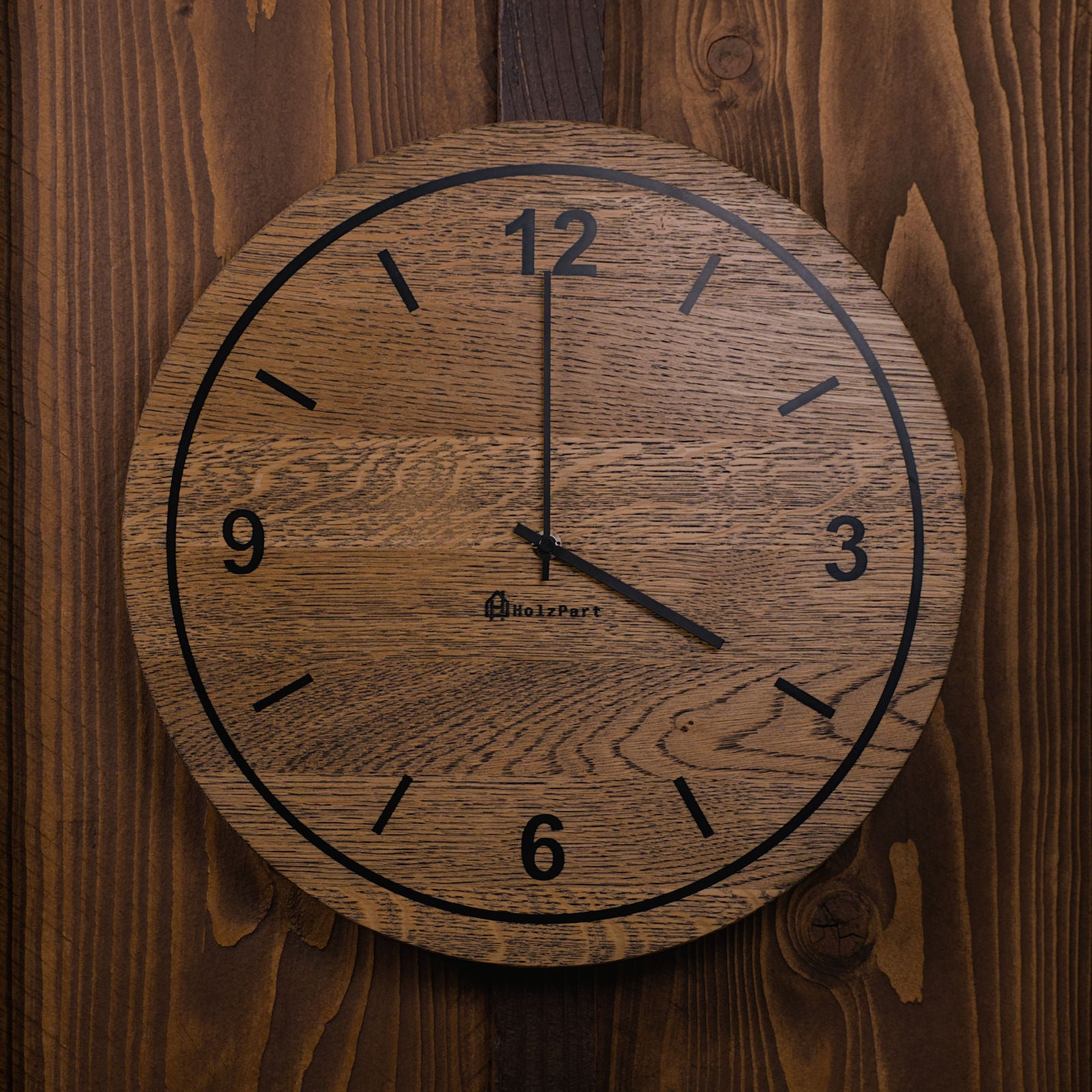 Runde Wanduhr mit Ziffern und Kreis-Design aus colour geölter Eiche – Frontalansicht, handgefertigt im Solothurner Unterleberberg von HolzPart.