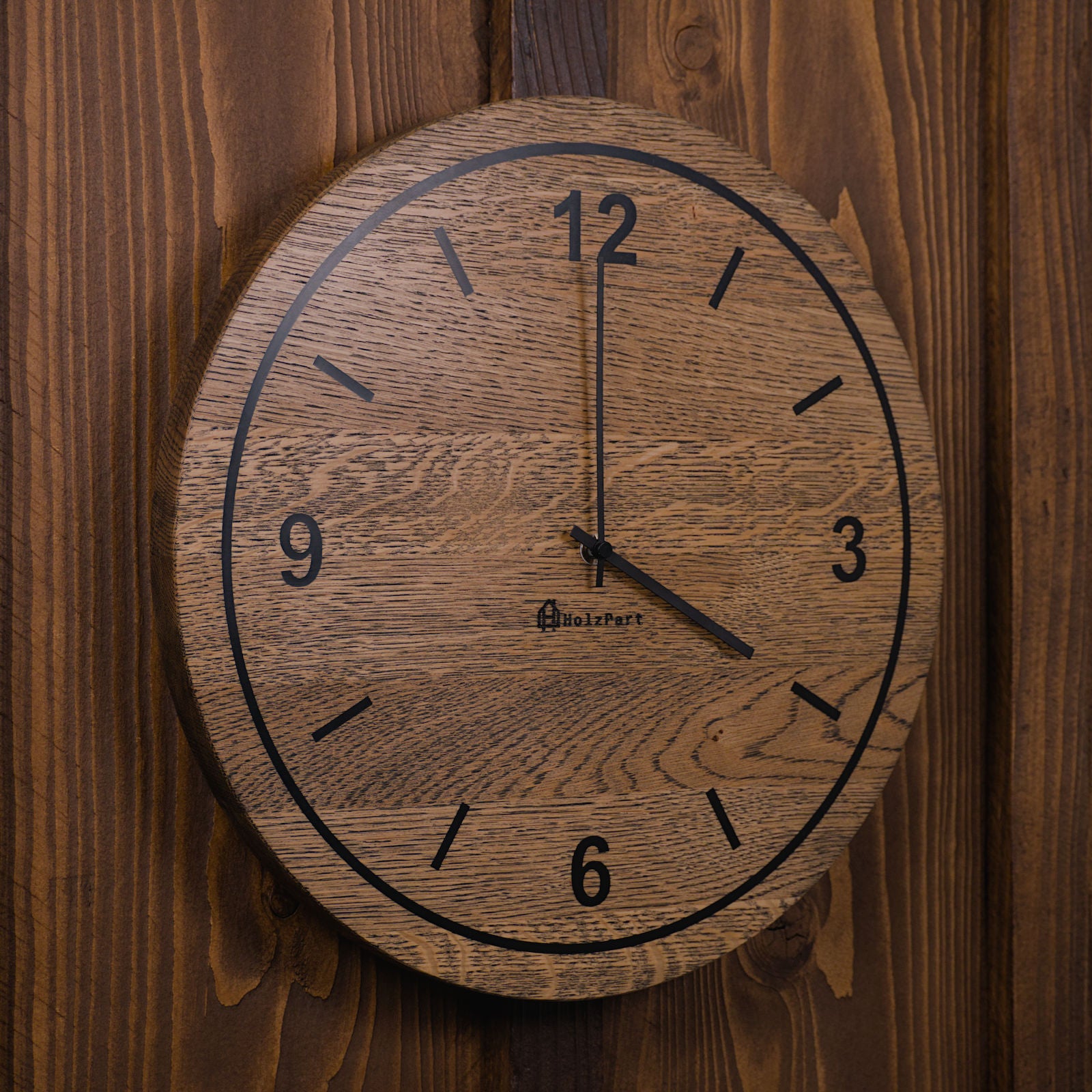 Handgefertigte runde Wanduhr mit Ziffern und Kreis-Design aus colour geölter Eiche – Seitenansicht der Uhr von HolzPart Schweiz.