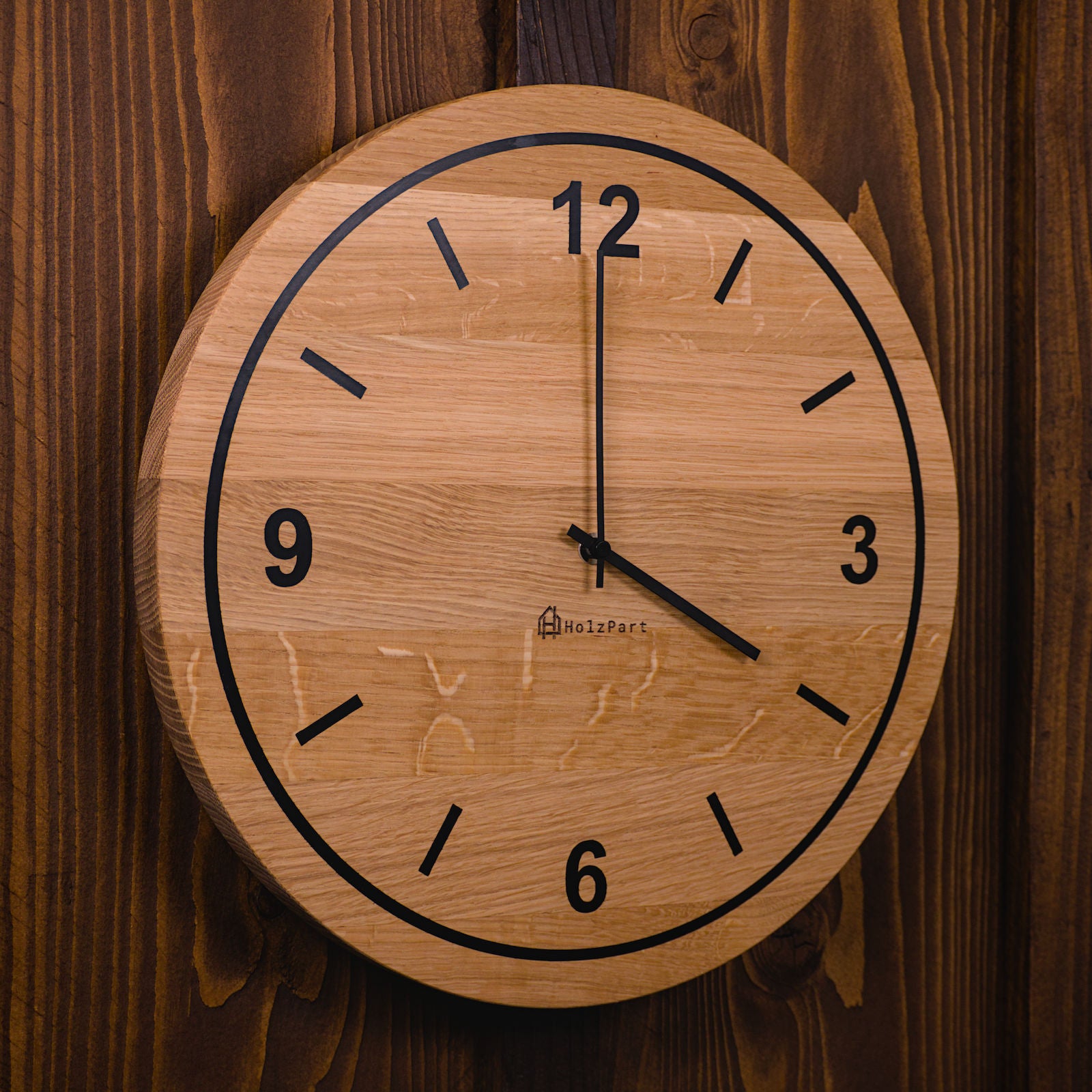 Handgefertigte runde Wanduhr mit Ziffern und Kreis-Design im Rohholzeffekt – Seitenansicht der Uhr von HolzPart Schweiz.