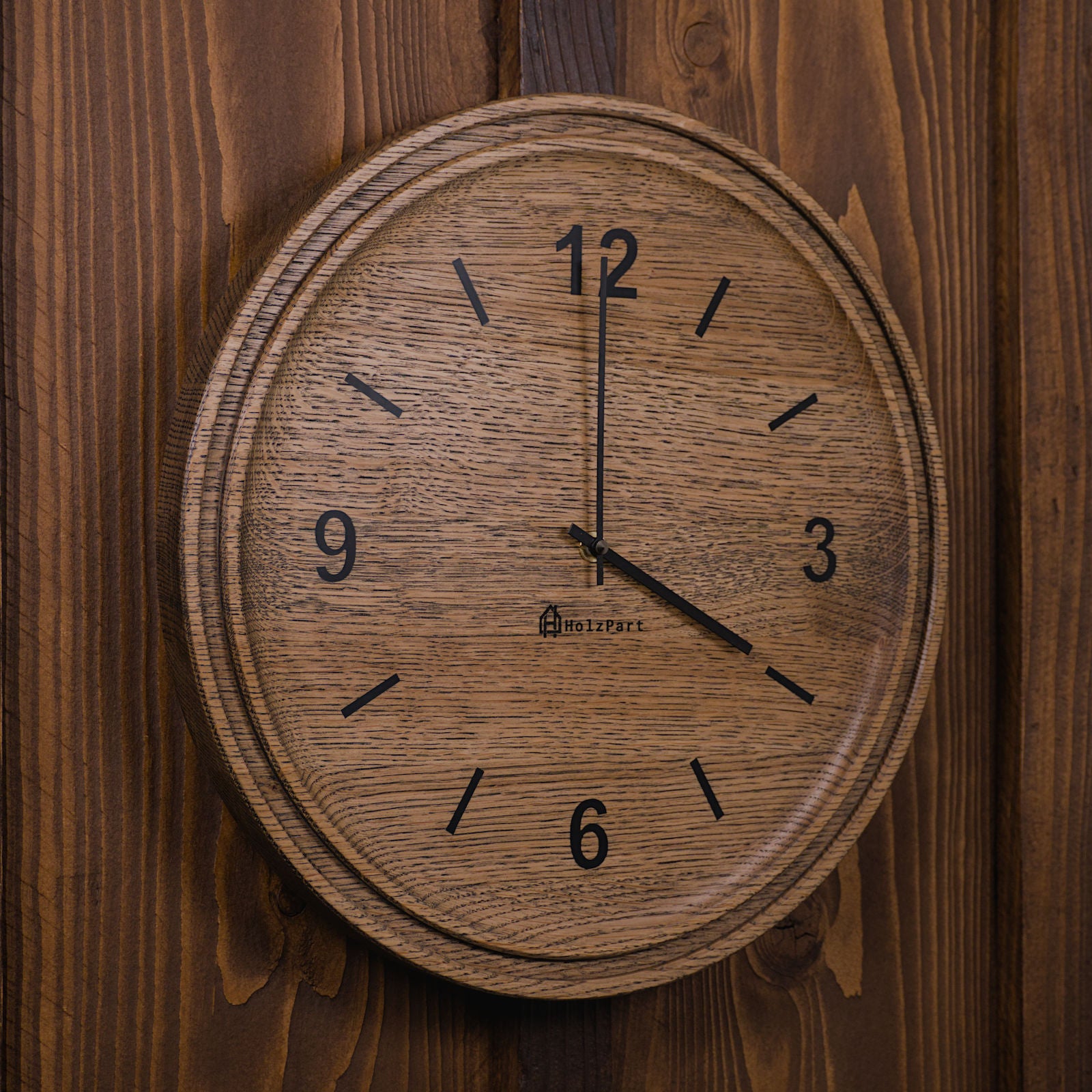 Handgefertigte runde Wanduhr mit Ziffern und doppeltem Rand aus colour geölter Eiche – Seitenansicht der Uhr von HolzPart Schweiz.