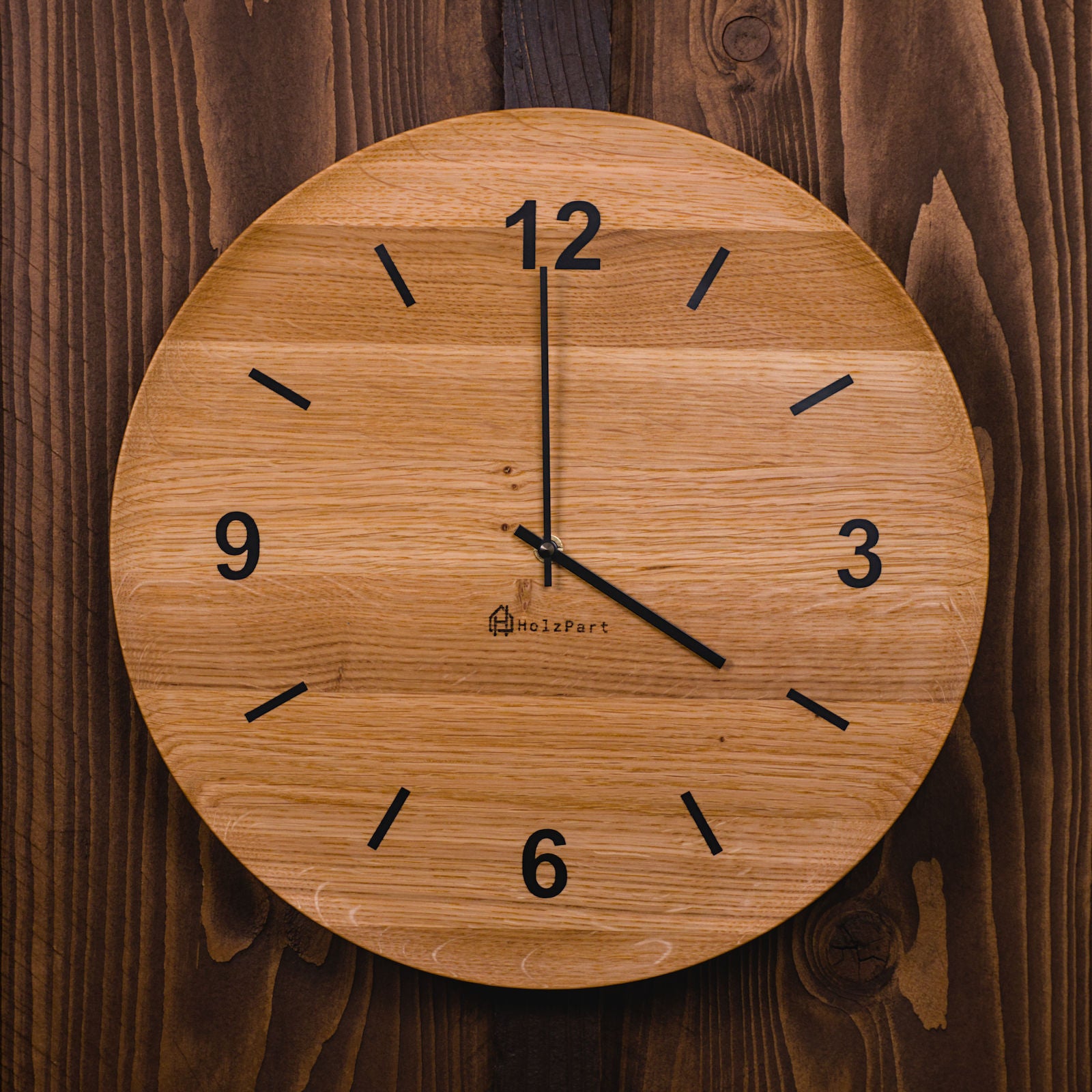 Runde Wanduhr mit Ziffern und flacher Schalenform aus klassisch geölter Eiche – Frontalansicht, handgefertigt im Solothurner Unterleberberg von HolzPart.