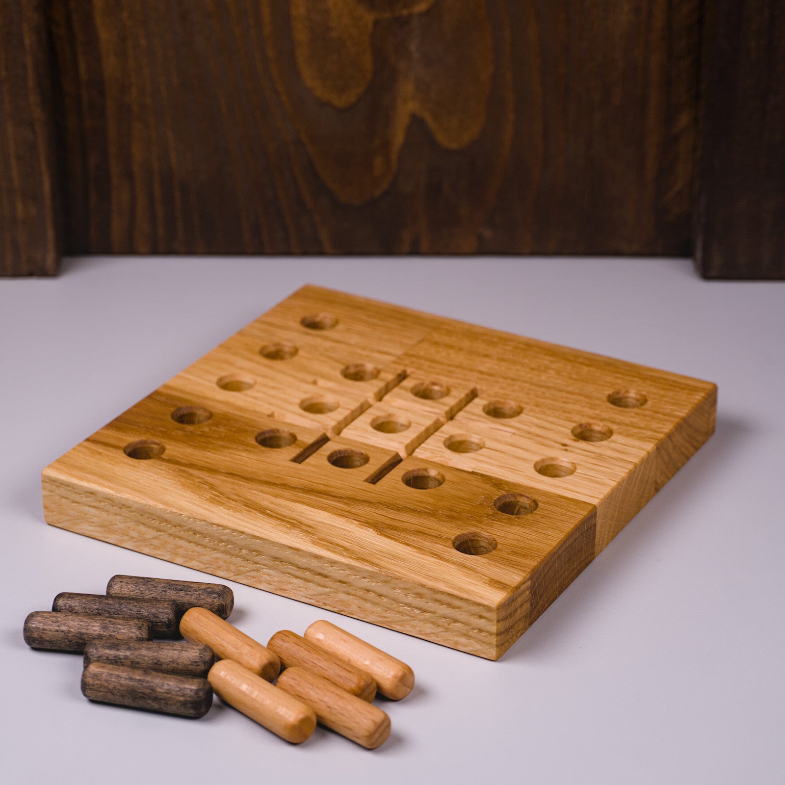 HolzPart Tic Tac Toe aus Eichenholz, linke Seitenansicht mit sichtbarer Maserung und eingelegten Holzspielsteinen.