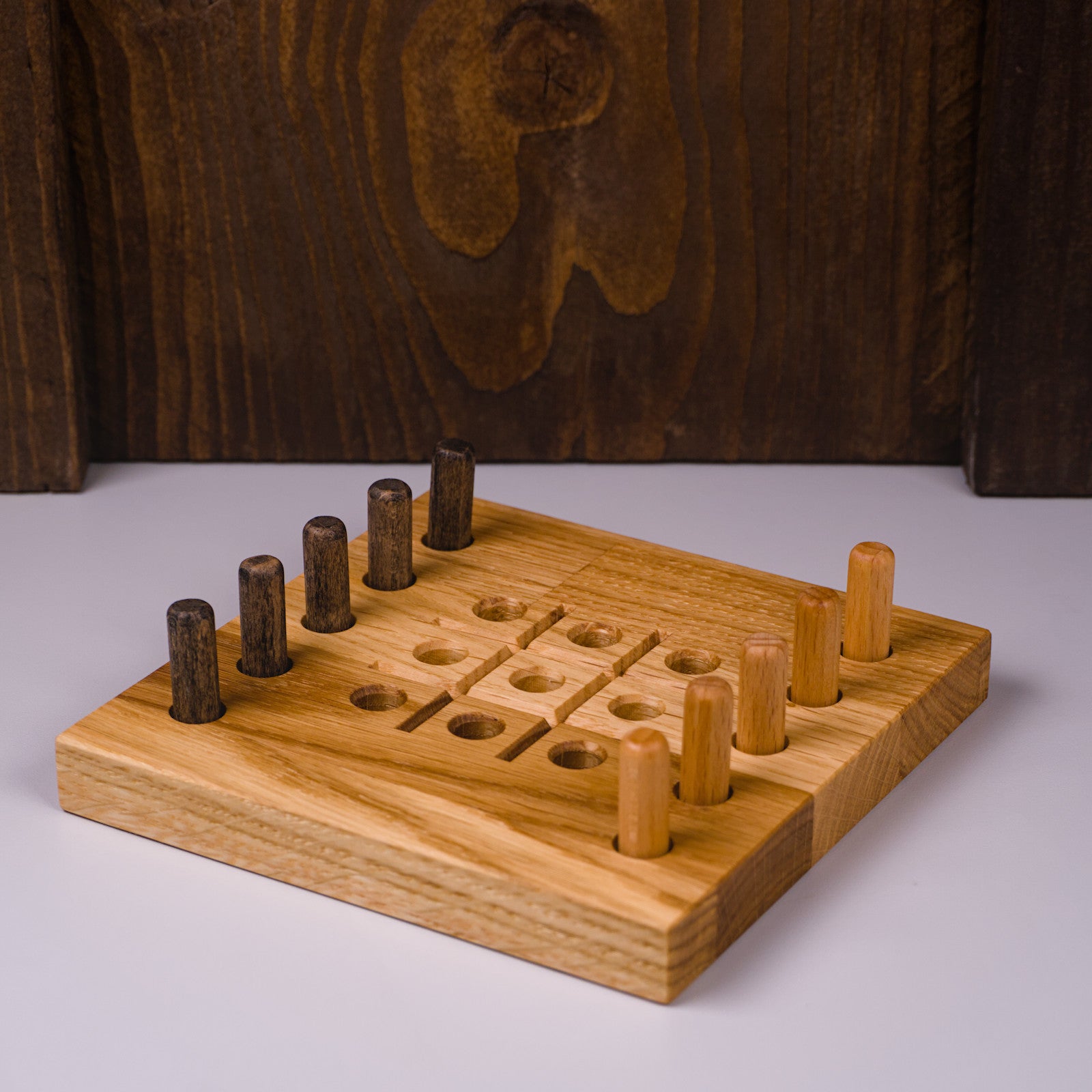 Tic Tac Toe Spiel aus Eichenholz von HolzPart, seitliche Ansicht links, hell und dunkel geölte Spielsteine sichtbar.