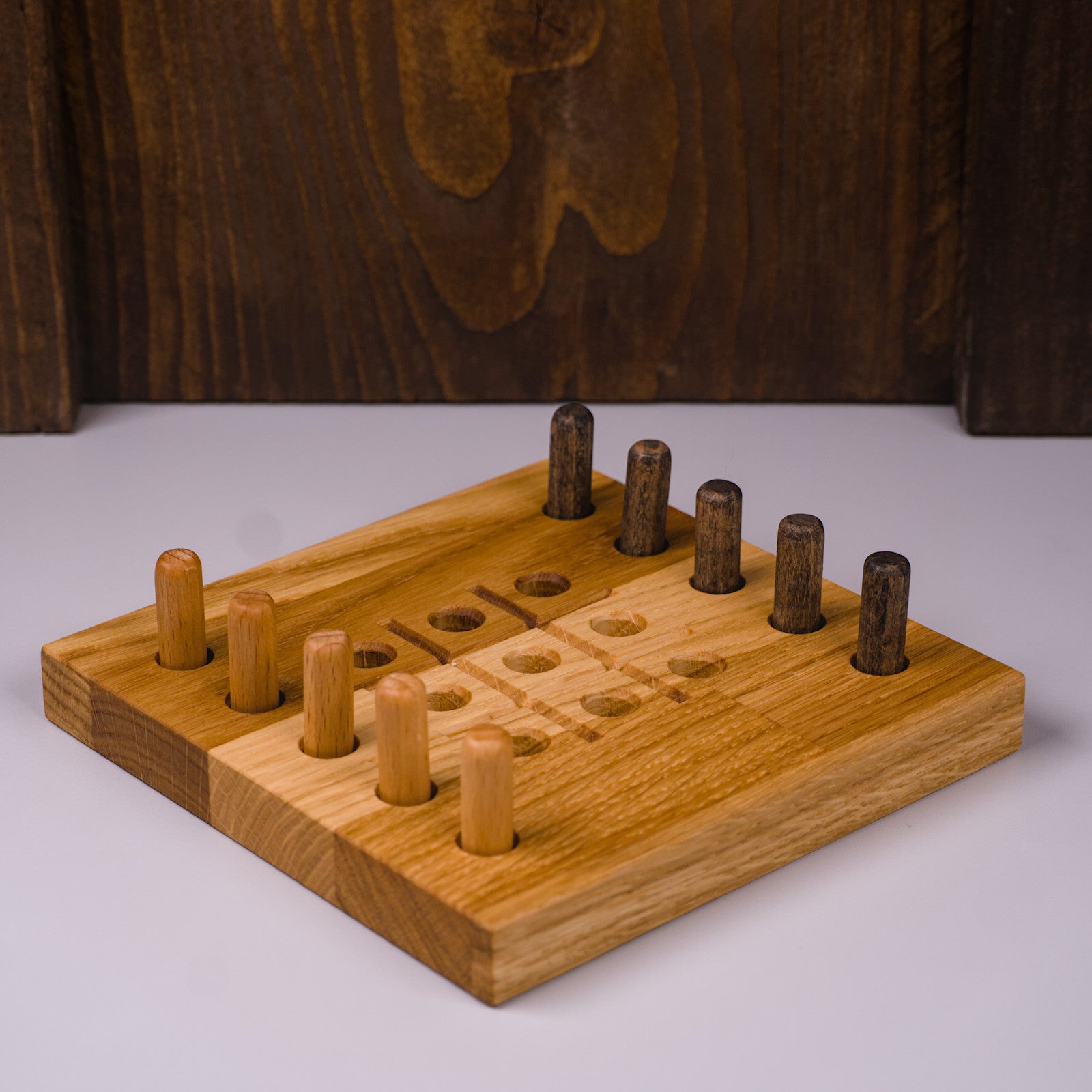 Tic Tac Toe Spielbrett aus Eichenholz von HolzPart, rechte Seitenansicht mit hellen und dunklen Spielsteinen.